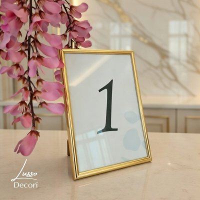 Numer na stół na przyjęcie w złotej ramce.