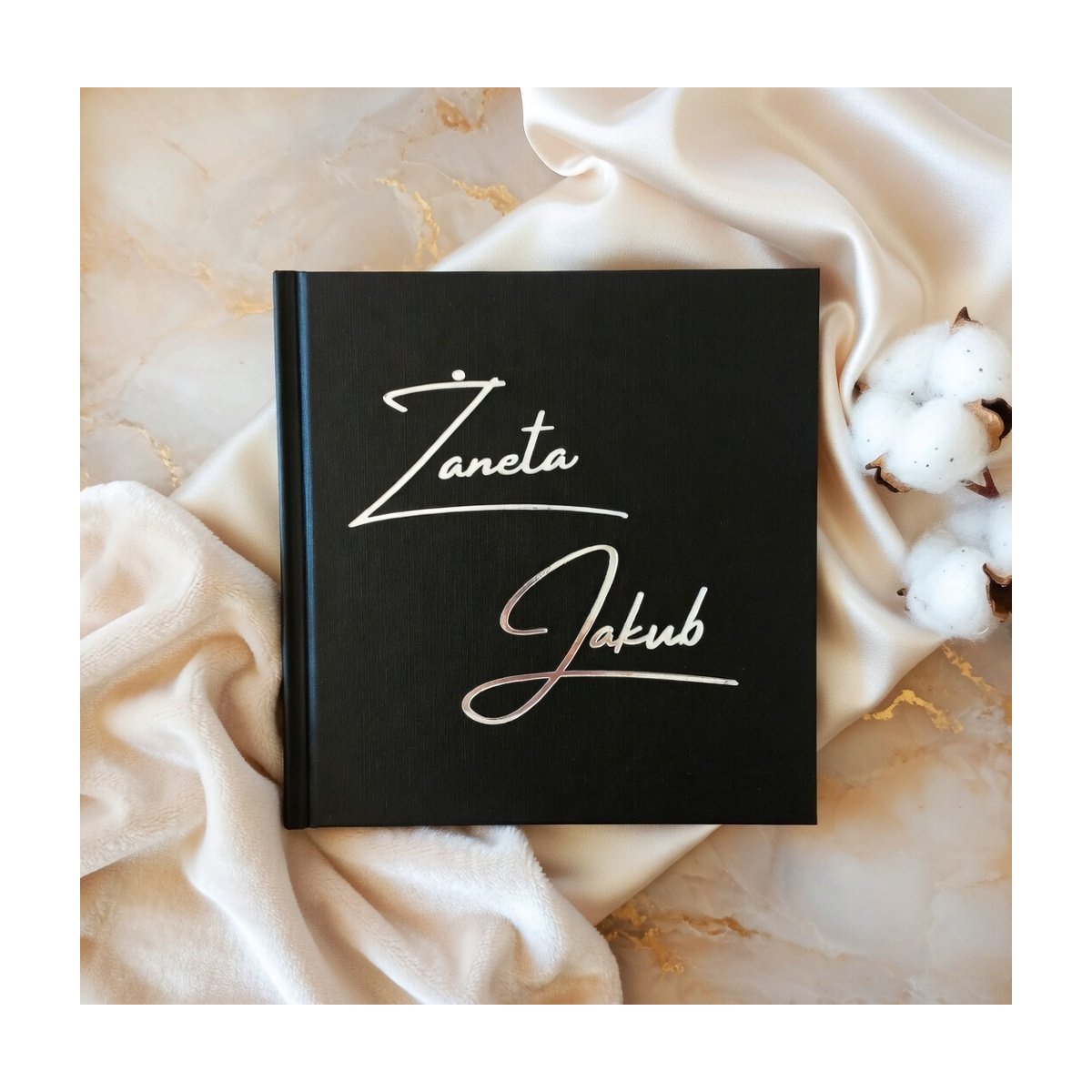 Czarna księga gości z lustrzanymi srerbnymi imionami na okładze na przyjęcie ślubne w stylu minimalistycznym lub glamour
