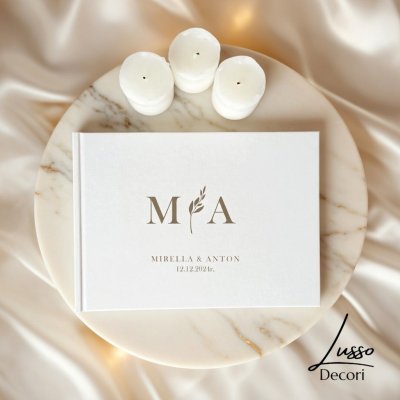 Pozioma księga gości w kolorze białym z grawerowaną personalizacją i gałązka na przyjęcie weselne w stylu boho