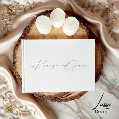 Pozioma księga gości z białą okładką i grawerowanym napisem na przyjęcie weselne, chrzest lub komunię.