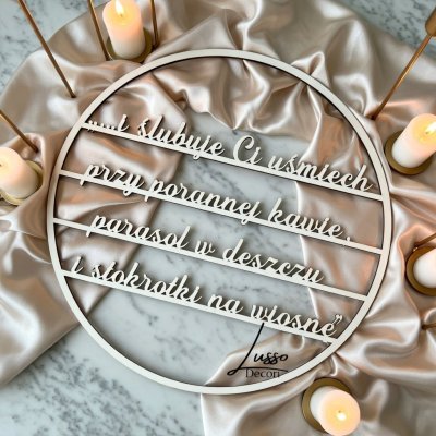 Drewniana obręcz z cytatem "I ślubuję Ci" jako dekoracja ścianki za państwem młodych