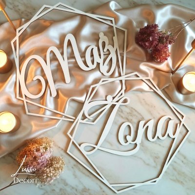 Drewniana obręcz heksagon z napisem mąż i żona jako dekoracja na ściankę za państwem młodych.